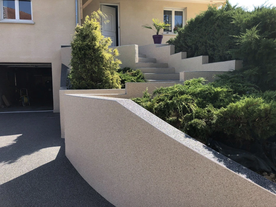 Escalier extérieur moderne en béton avec rampe intégrée, aménagement paysager avec conifères et arbustes