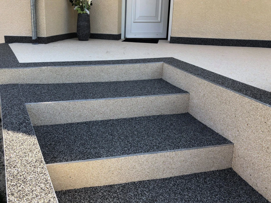 Escalier intérieur en granito avec marches noires et contremarches beiges, rampe d'angle assortie