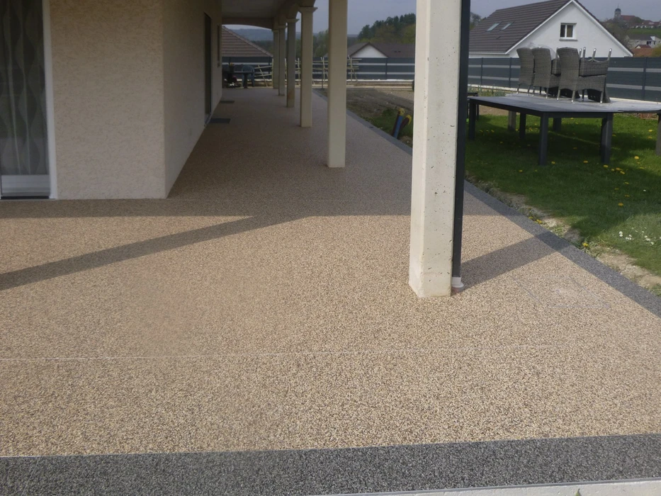 Terrasse extérieure d'immeuble moderne avec colonnes en béton et table métallique
