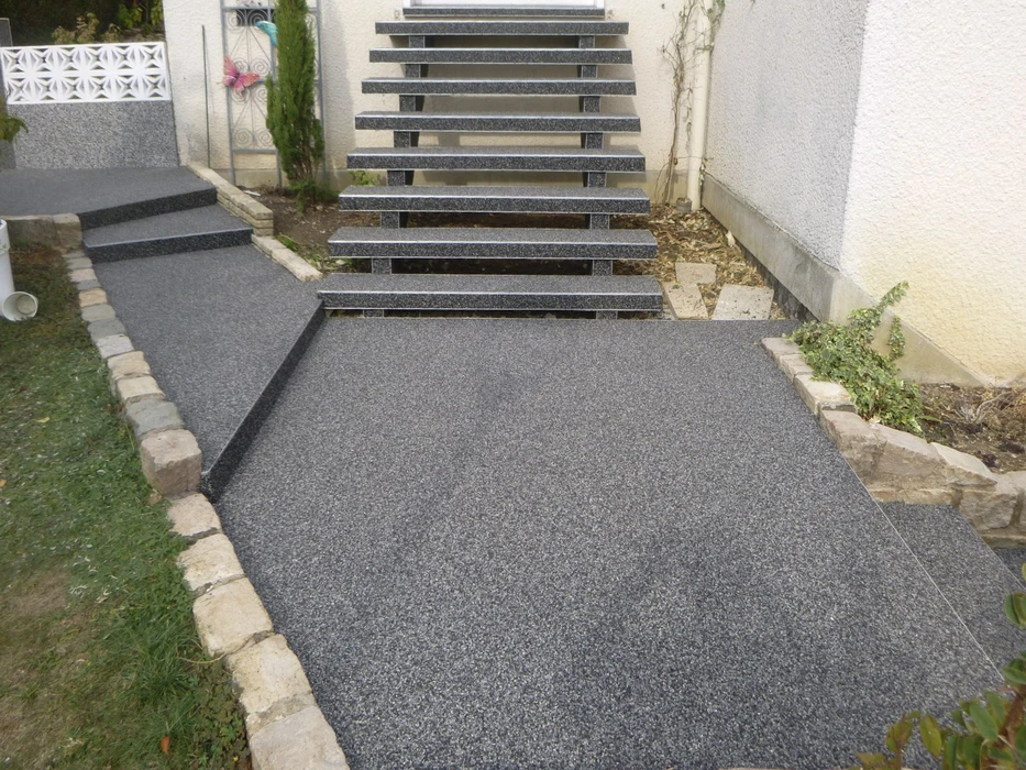Aménagement extérieur résidentiel avec escalier en granit gris et terrasse