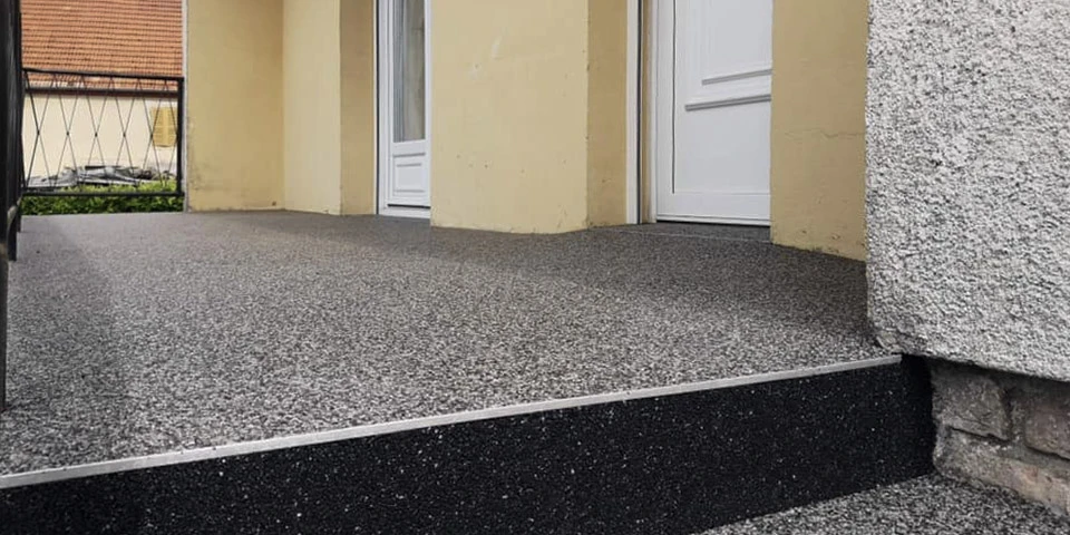 Terrasse extérieure d'immeuble résidentiel avec revêtement de sol en résine époxy antidérapante grise