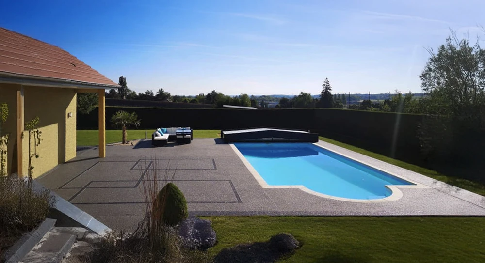 Espace extérieur résidentiel avec piscine creusée rectangulaire à eau bleue claire