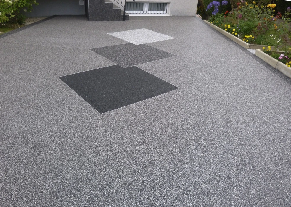 Terrasse extérieure moderne avec deux fauteuils blancs en résine tressée à structure métallique disposés autour d'une table basse ronde en rotin foncé