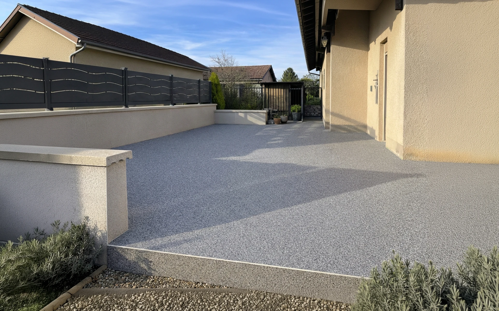 Terrasse moderne d'appartement avec salon extérieur équipé de canapés en résine tressée, coussins blancs et bleus, table basse vitrée