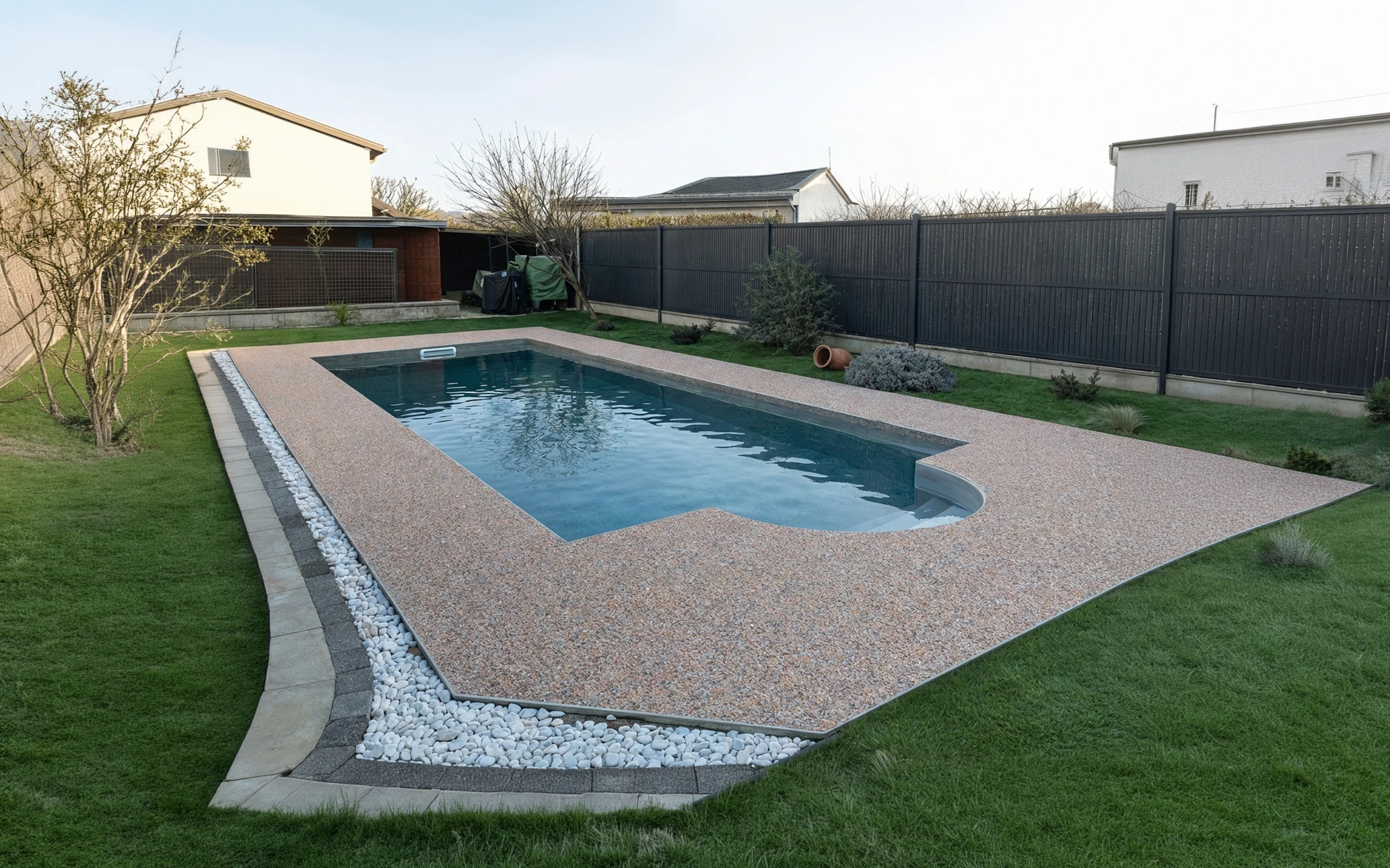 Aménagement extérieur de piscine avec margelles en béton gris disposées autour du bassin carrelé de mosaïques turquoise