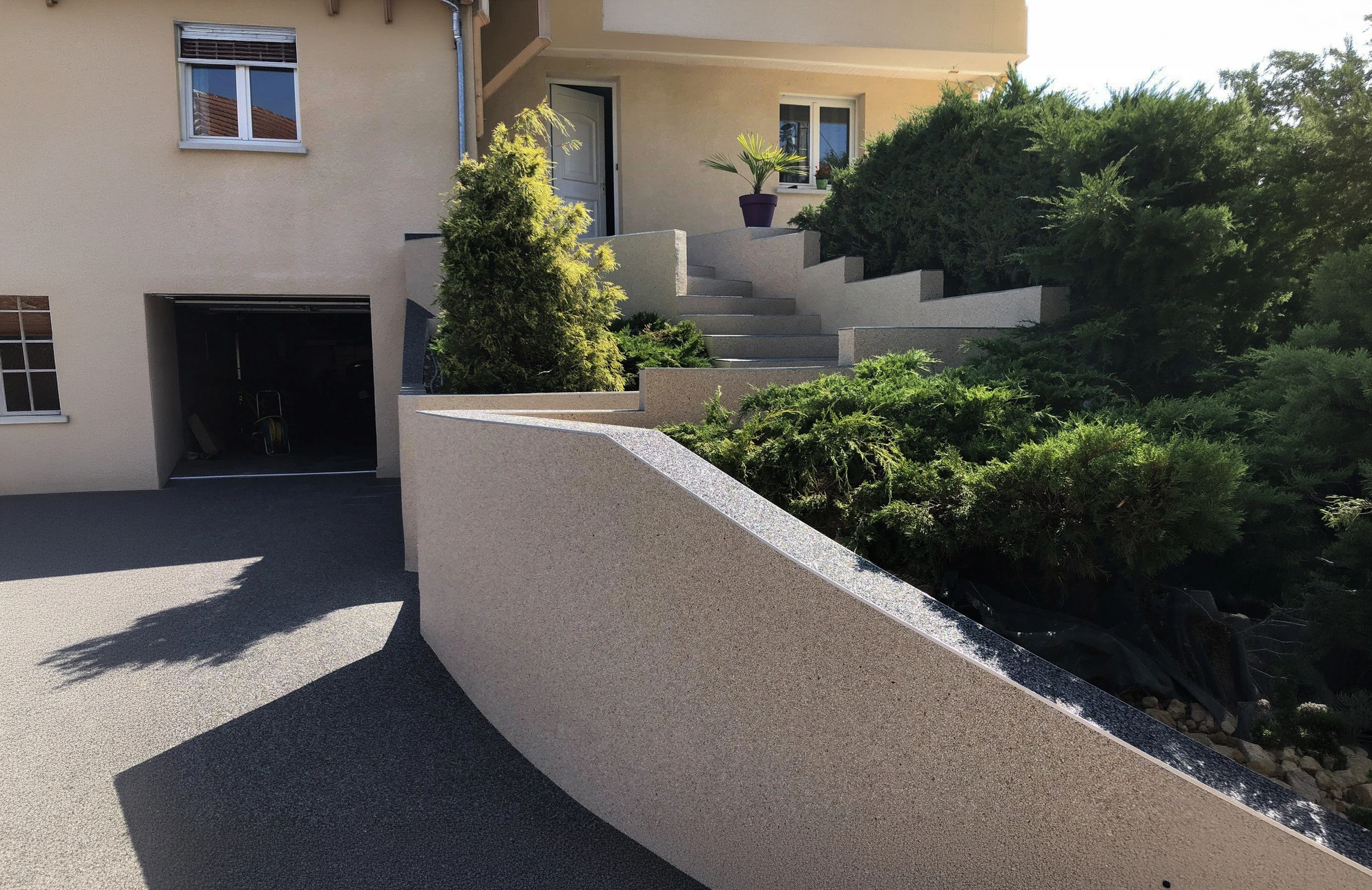 Jardin résidentiel avec deux chaises longues modernes en textilène gris sur pelouse